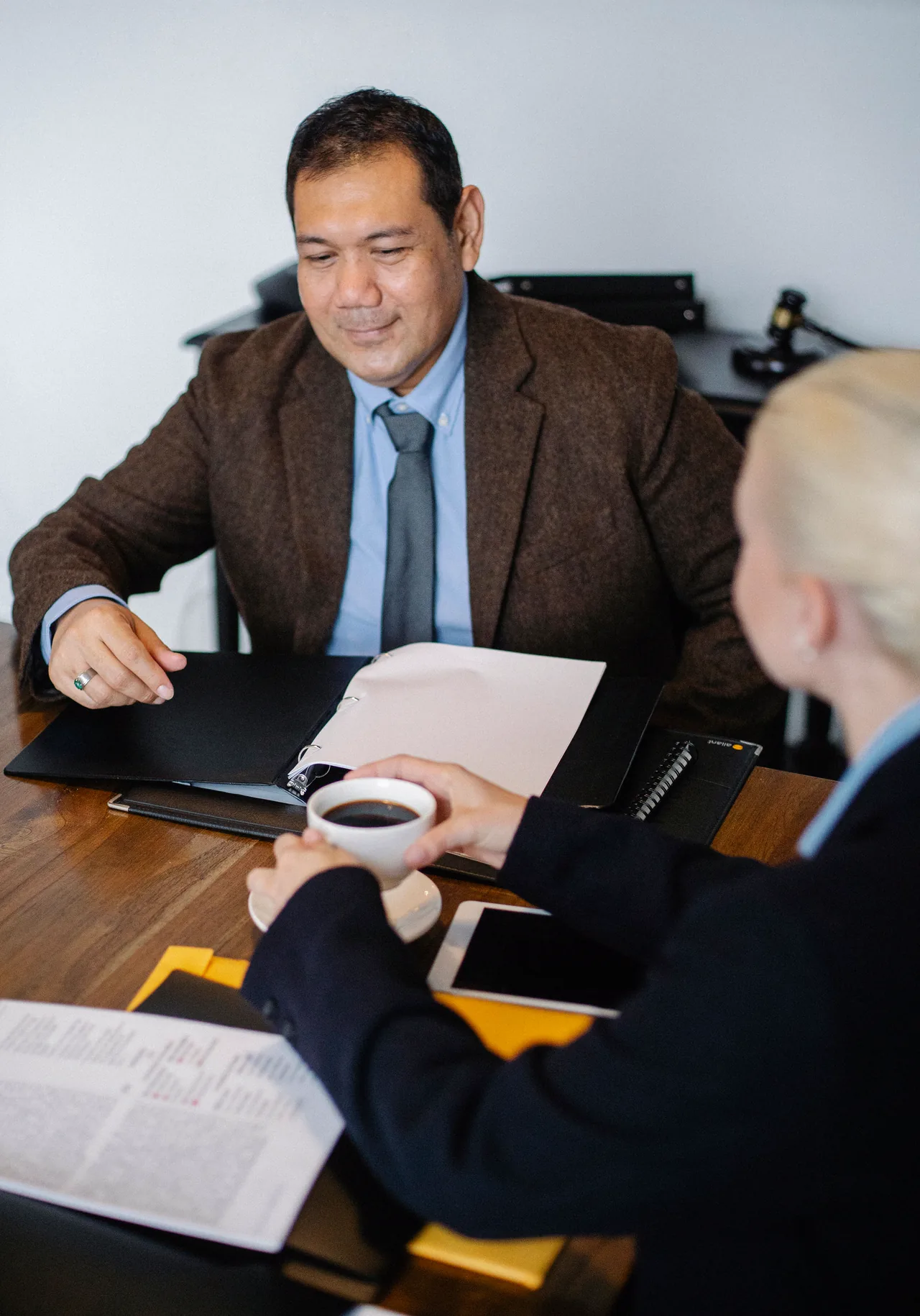 A lawyer smiling across his desk at a client